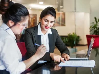 Deux femmes d'affaires travaillant sur un ordinateur portable.