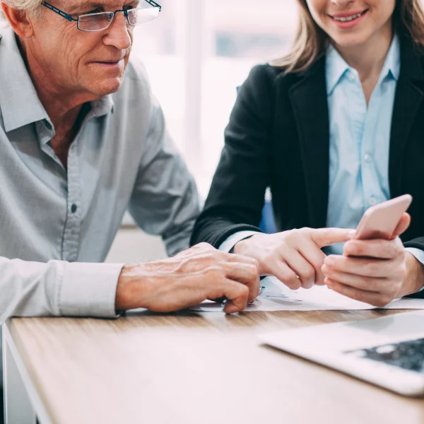 A man and woman at a table with a laptop, discussing options as independent lenders.